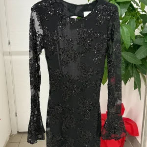 Abito corto a maniche lunghe semitrasparenti con paillettes e spacco sul retro