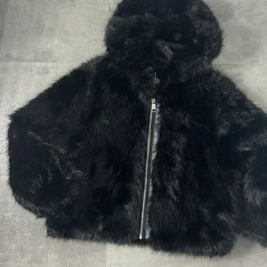 Pelliccia nera con cappuccio e tasche 4-14 anni