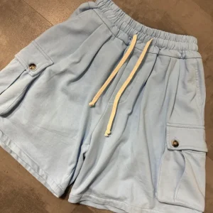 Pantaloncino cargo celeste in cotone con tasche laterali