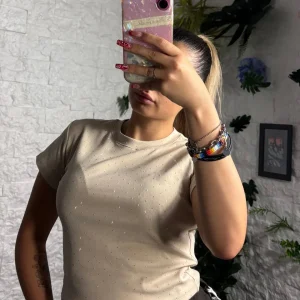 T-shirt crop-top brillantinata in tinta unita